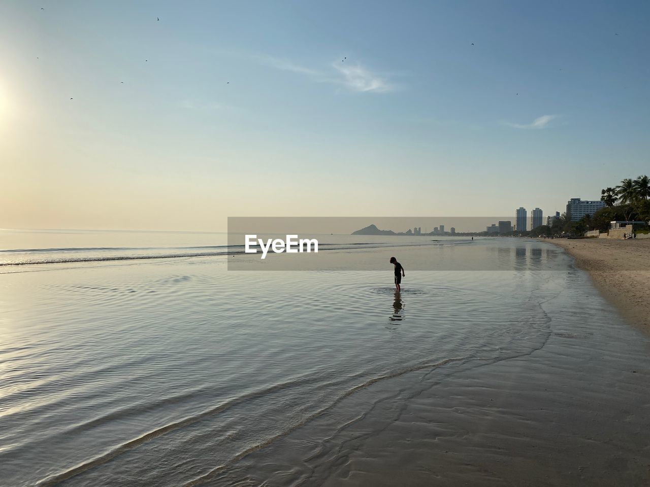 Child playing at sunrise at beach in early morning