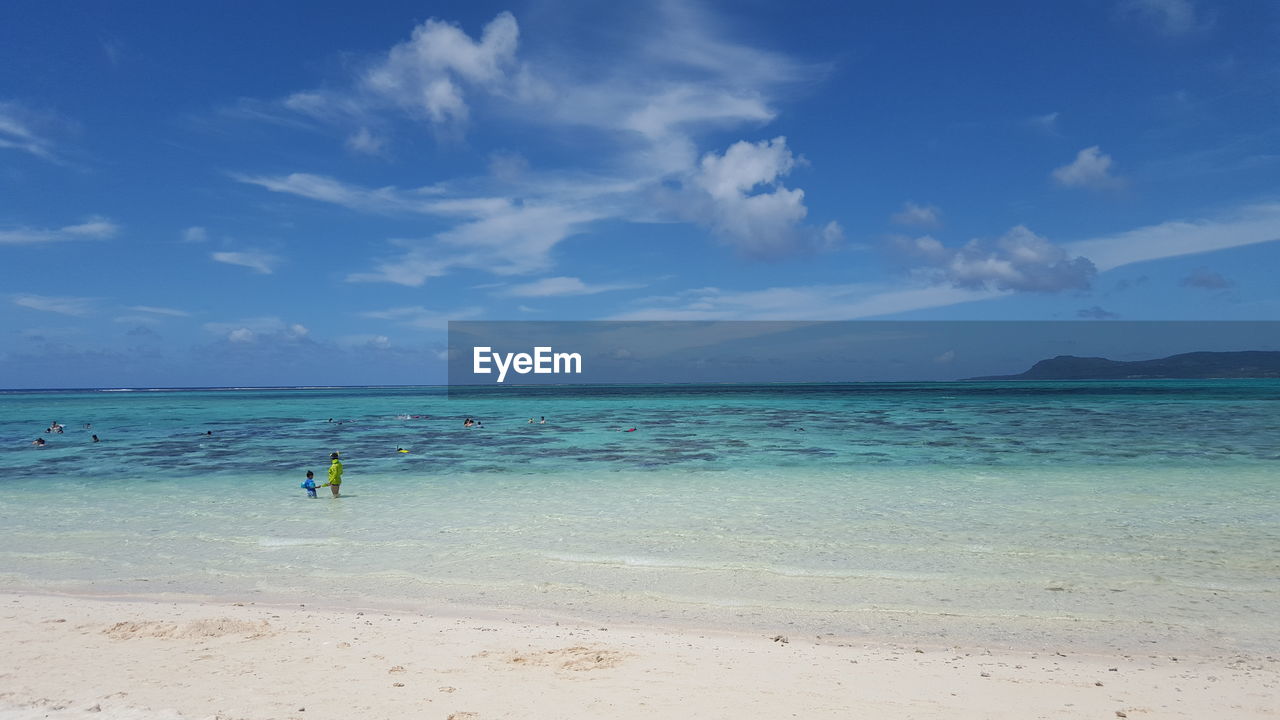 Scenic view of beach against cloudy sky