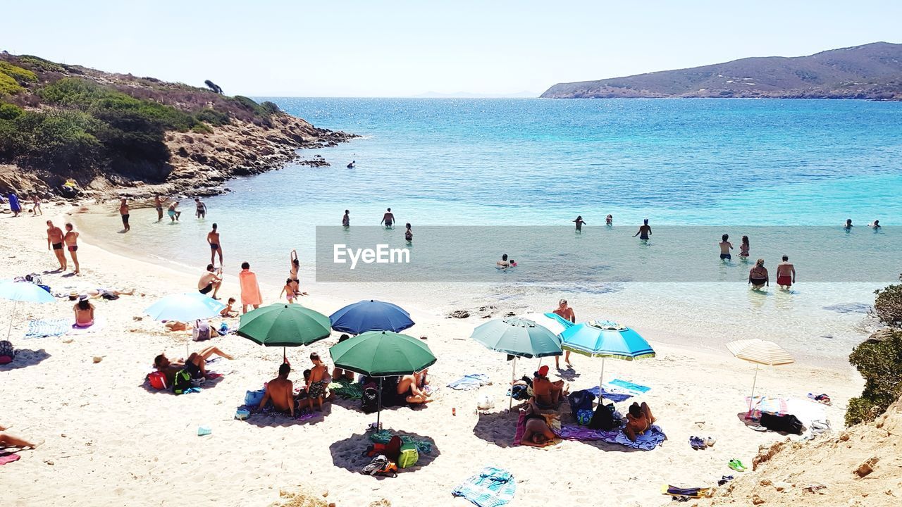 High angle view of people at beach against clear sky