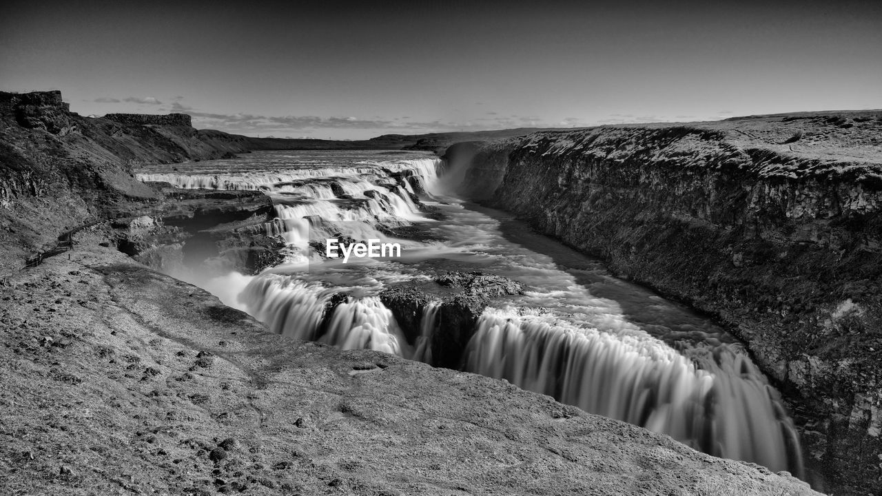 Scenic view of waterfall against sky