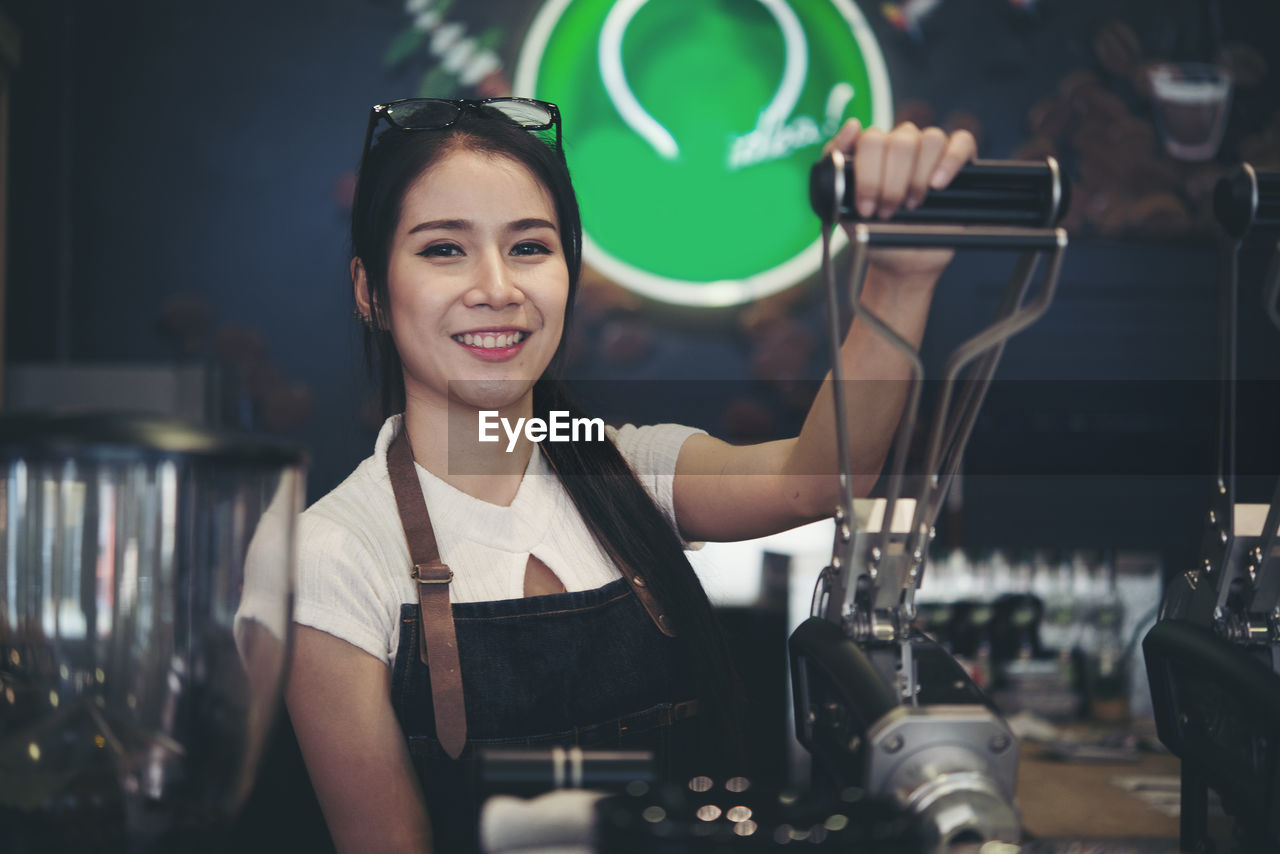 Portrait of smiling female barista working at cafe