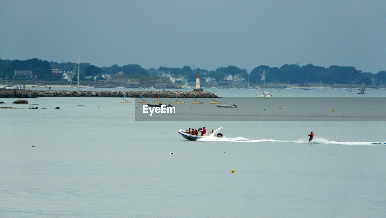 BOATS SAILING ON SEA AGAINST CLEAR SKY