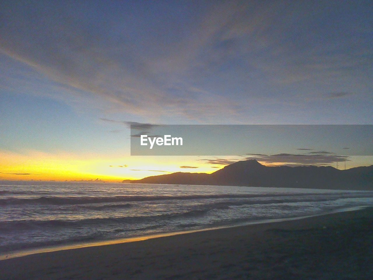 SCENIC VIEW OF BEACH DURING SUNSET