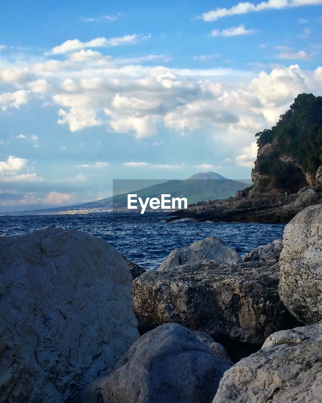 View of calm beach against cloudy sky