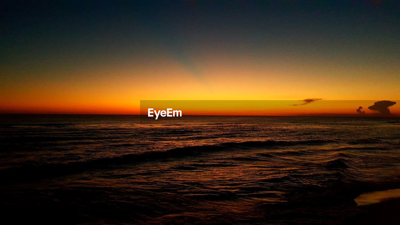 SCENIC VIEW OF SEA AGAINST SKY AT SUNSET