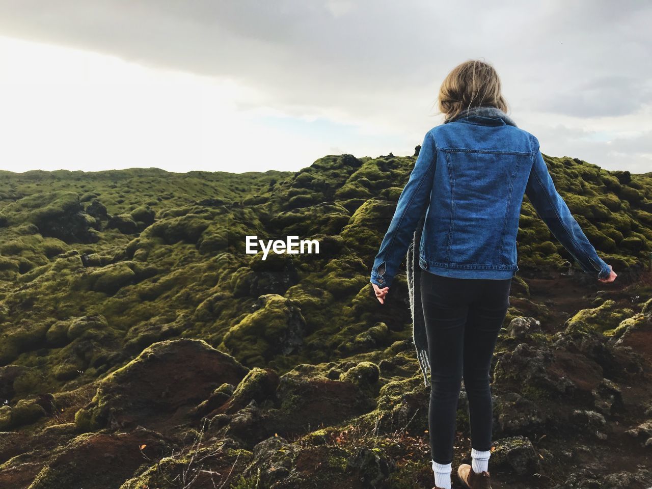 REAR VIEW OF WOMAN LOOKING AT MOUNTAIN AGAINST SKY