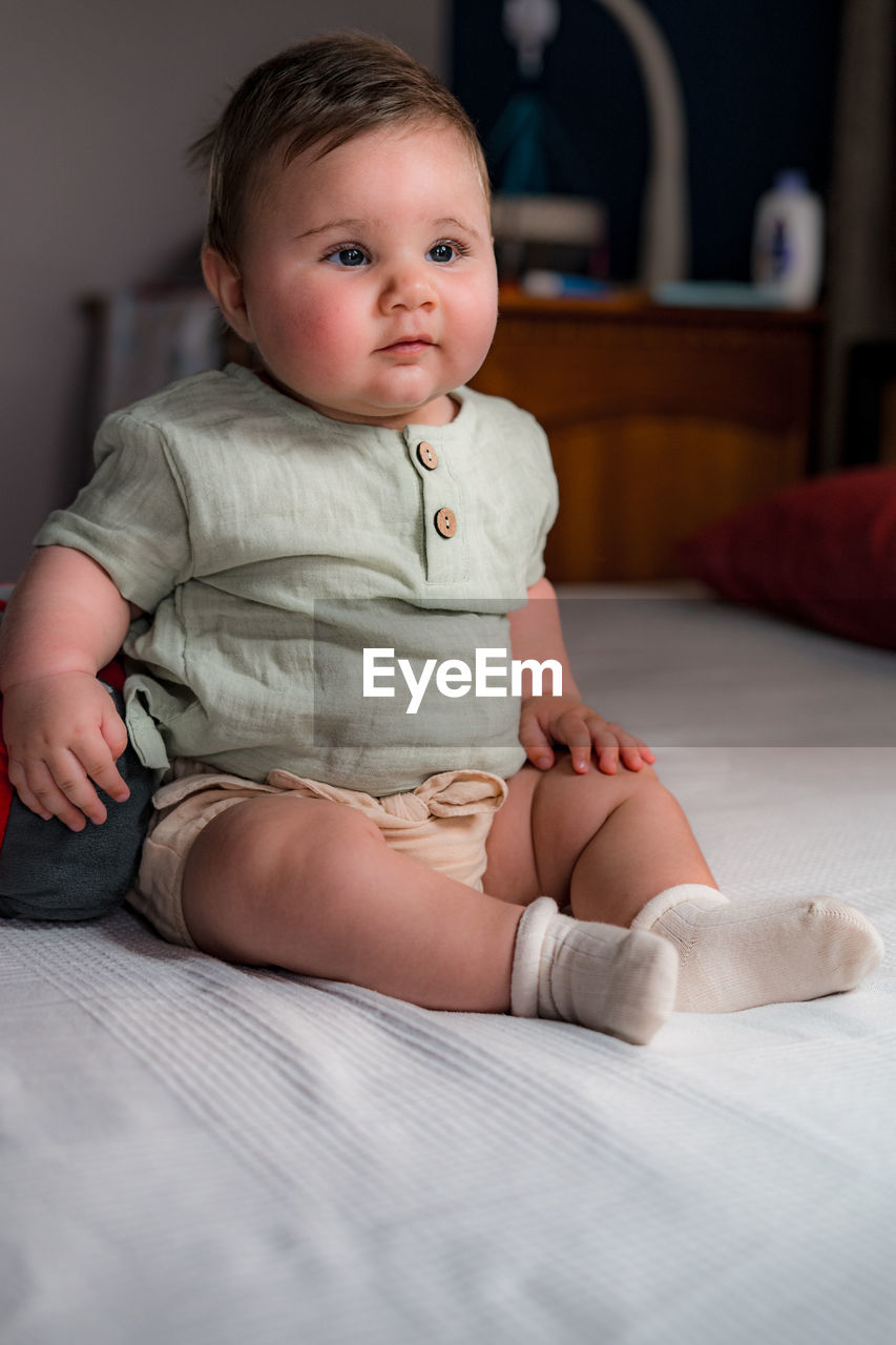 Sitting baby in vintage clothes for photo shoot