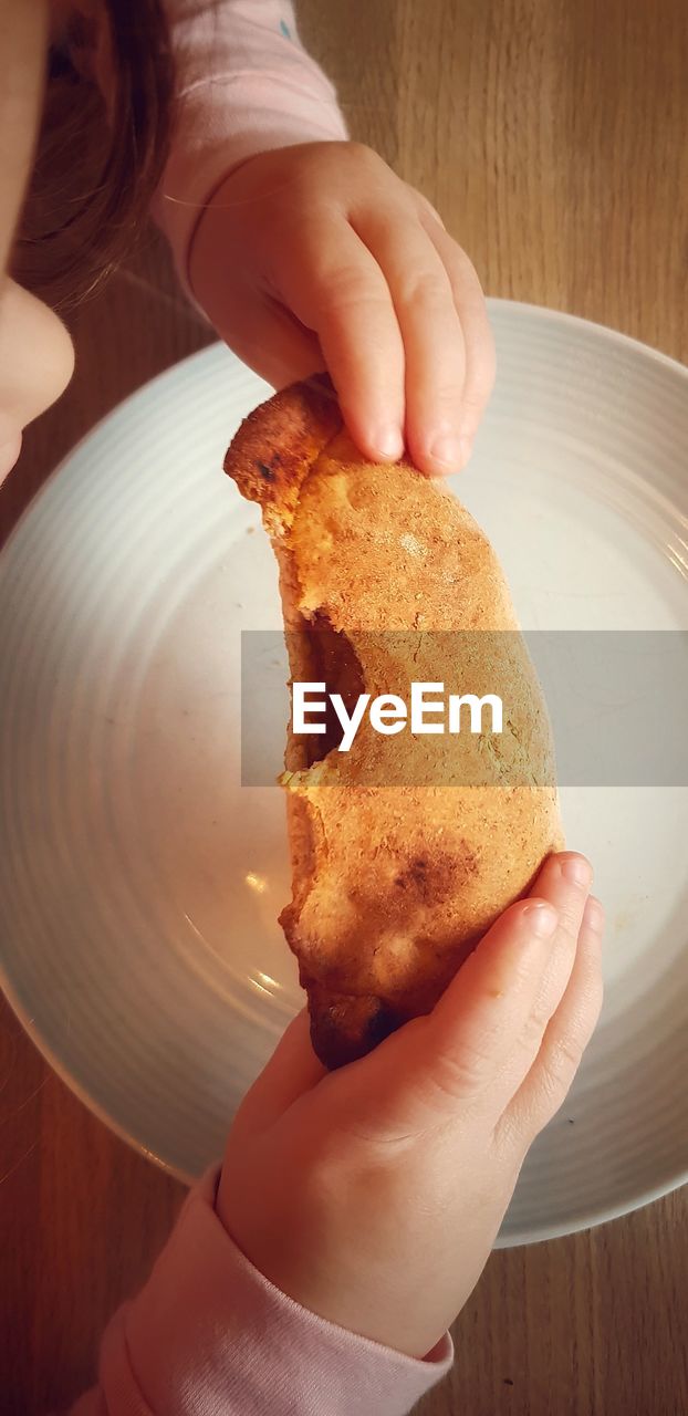 Midsection of girl eating food on table at home