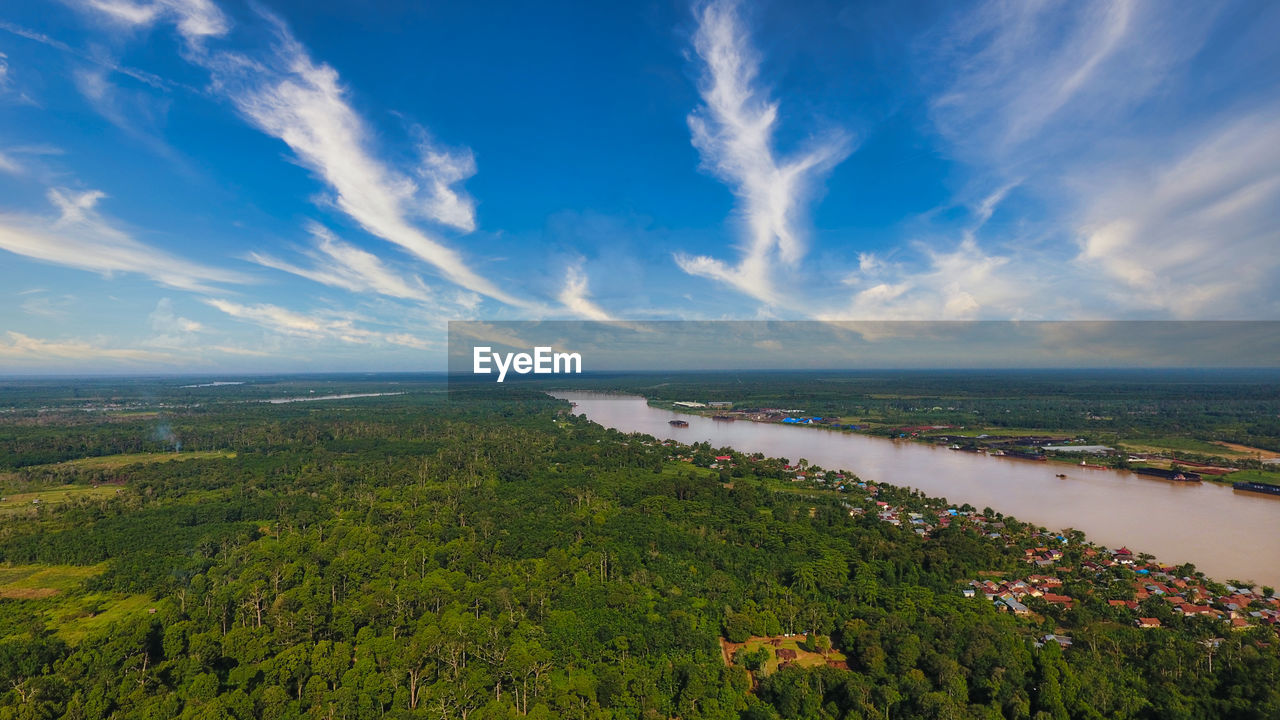 Aerial view of forest batanghari river , with muarojambi temple in the bright morning blue sky