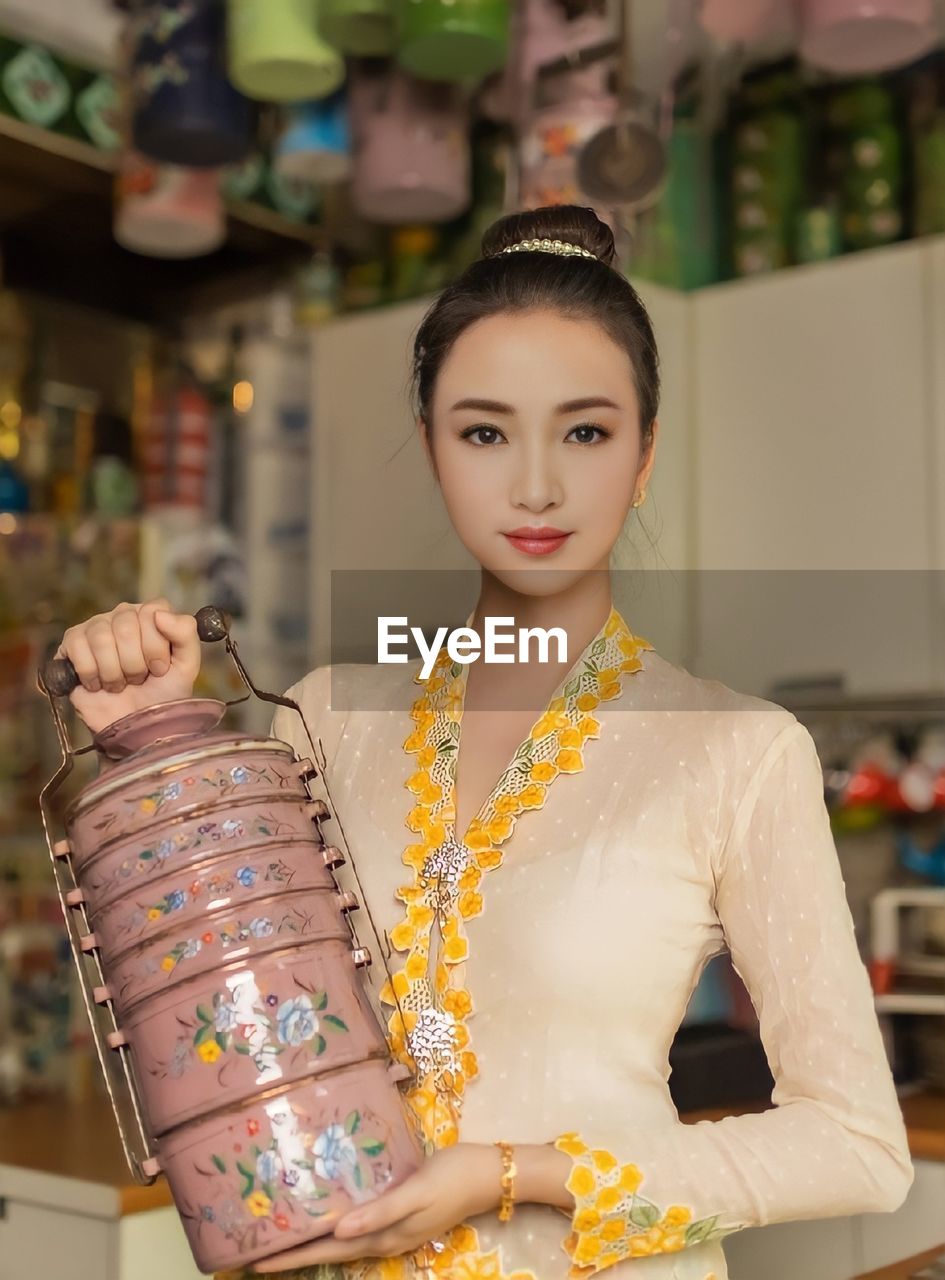 Portrait of young woman wearing kebaya standing in store