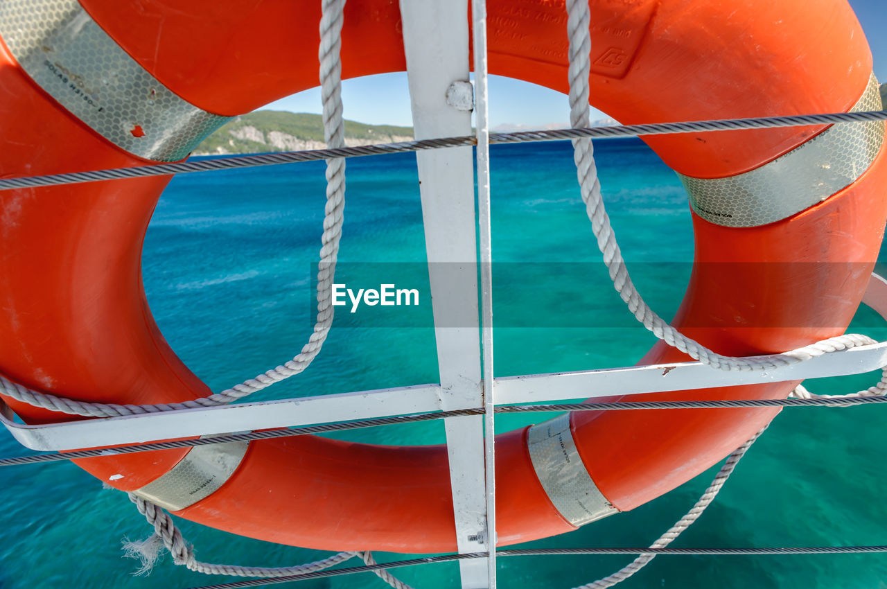 Close-up of boat moored in sea against sky