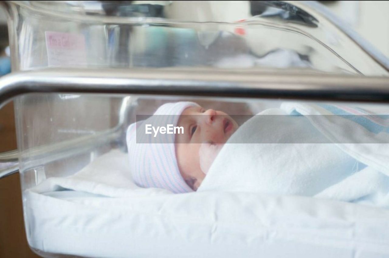 Close-up of baby girl sleeping in incubator