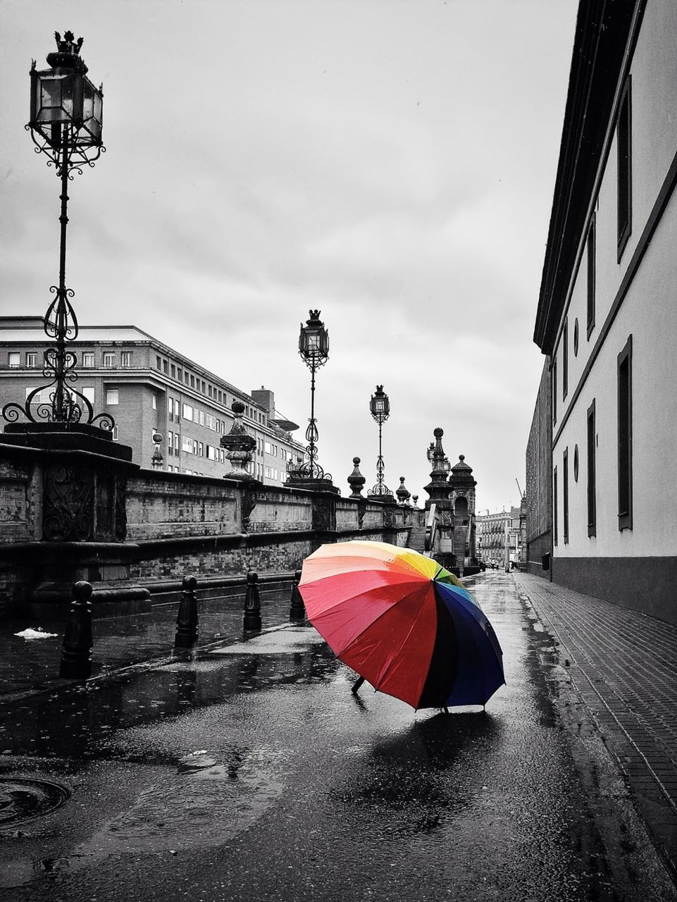 Large colorful umbrella on the road along buildings