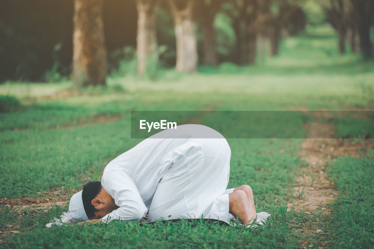 Religious muslim man praying  outdoor at quiet nature  environment sun beams.