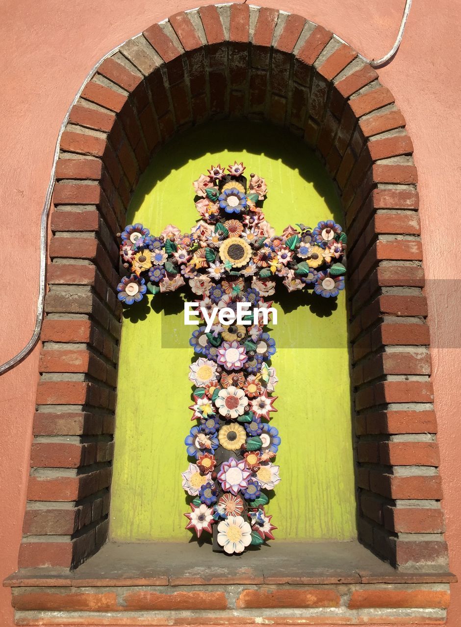 Cross decorated with artificial flowers