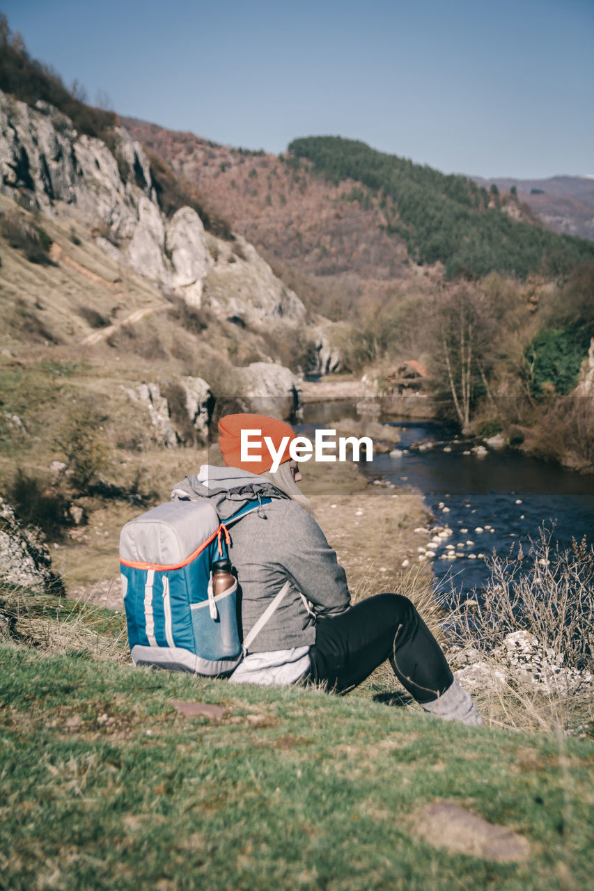 Rear view of woman sitting on mountain