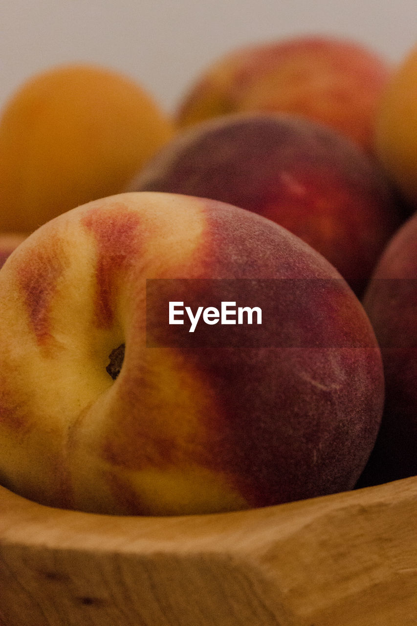 Close-up of peach in wood bowl