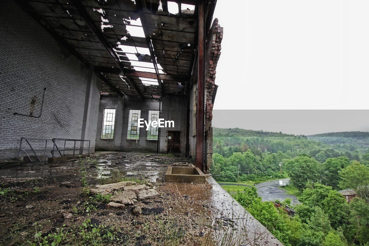 Abandoned house against green mountains