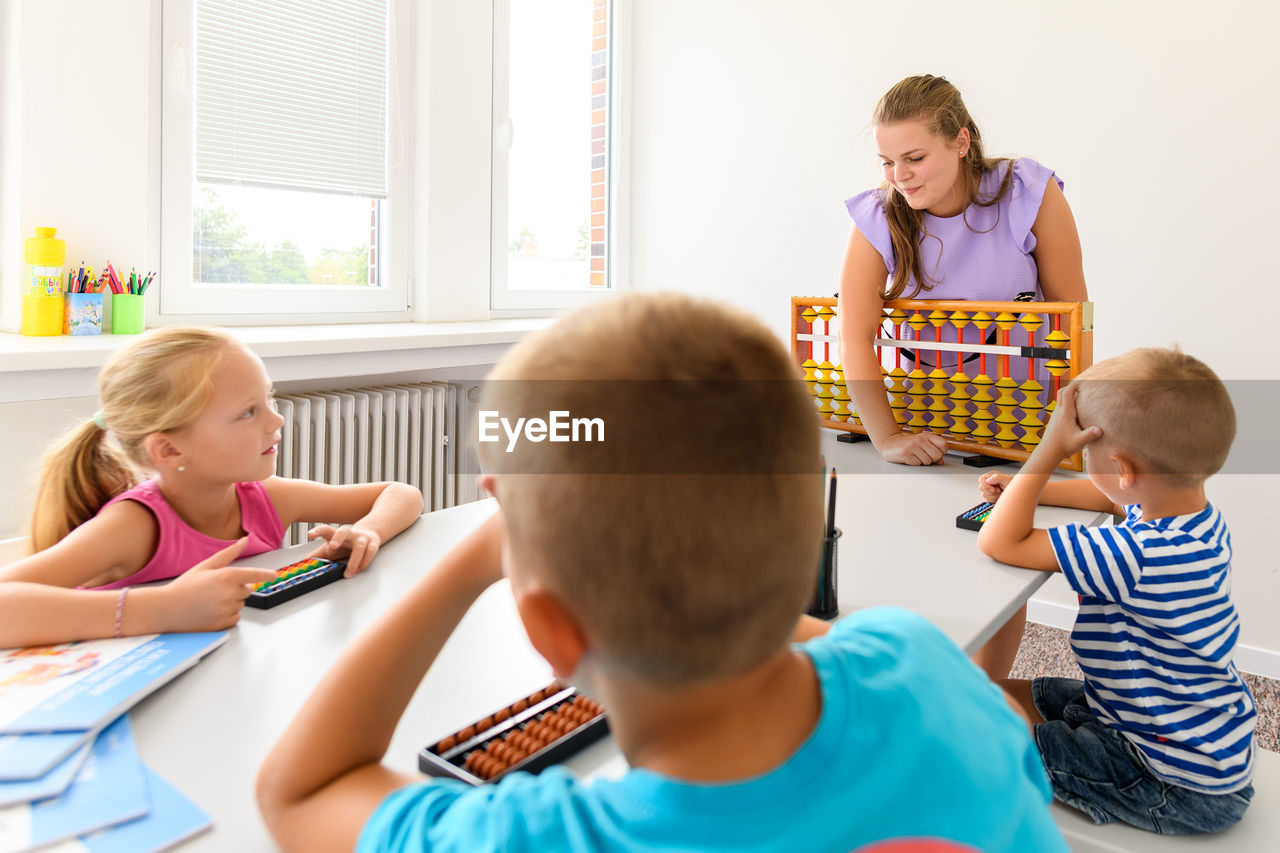 Group of children doing playful exercises with their therapist. learning difficulty concept.