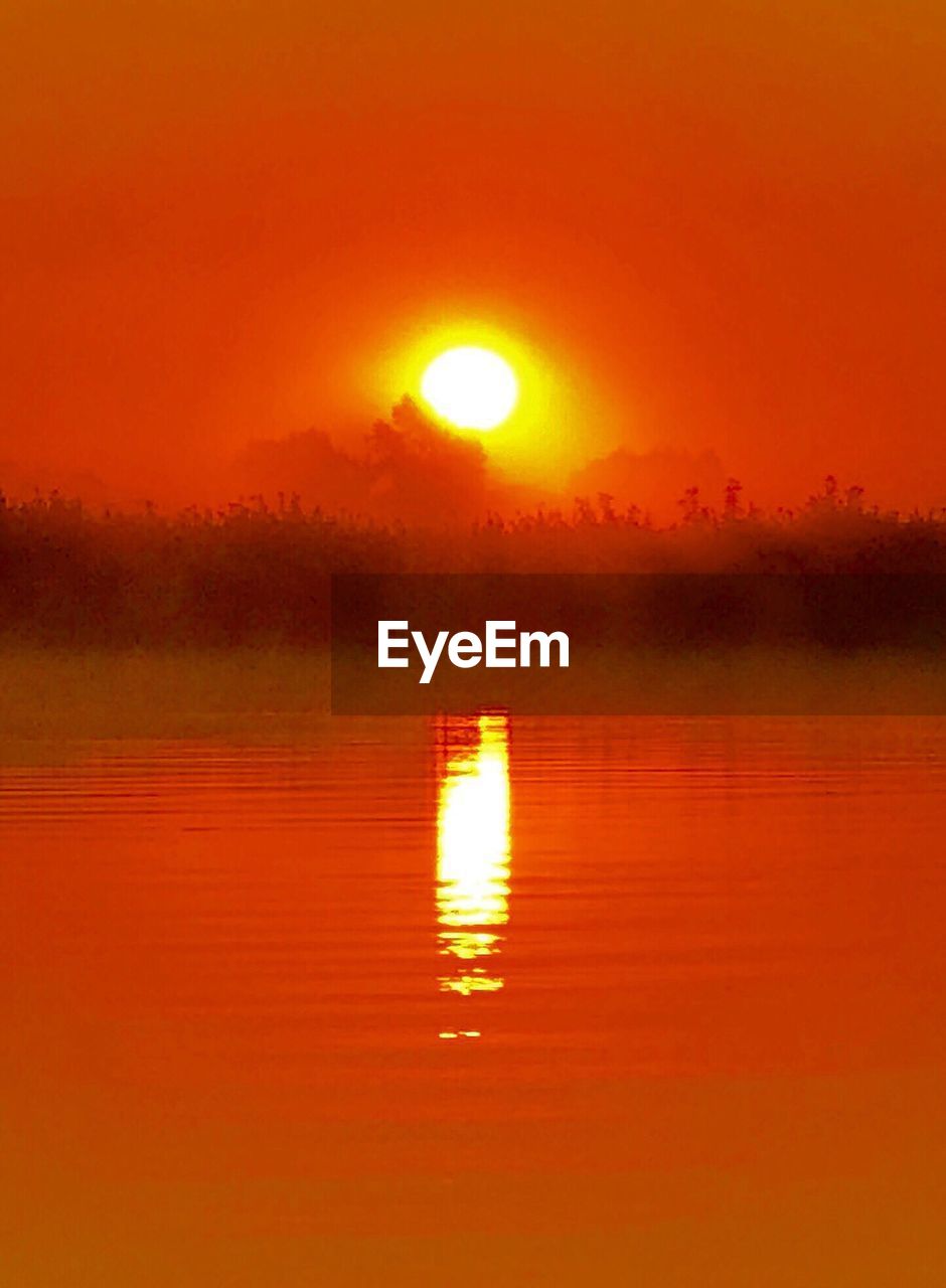 SCENIC VIEW OF LAKE AGAINST SKY AT SUNSET