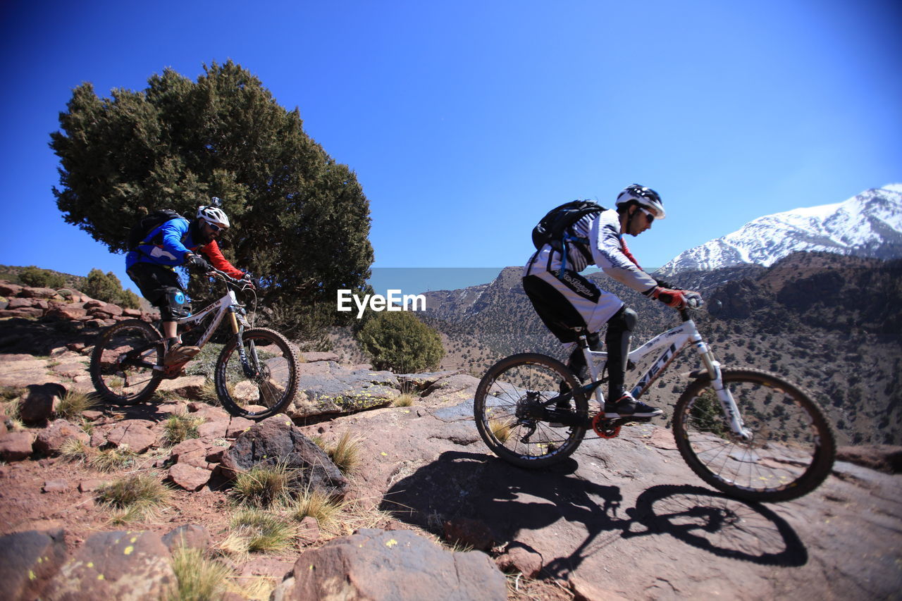 Low angle view man riding bike on mountain