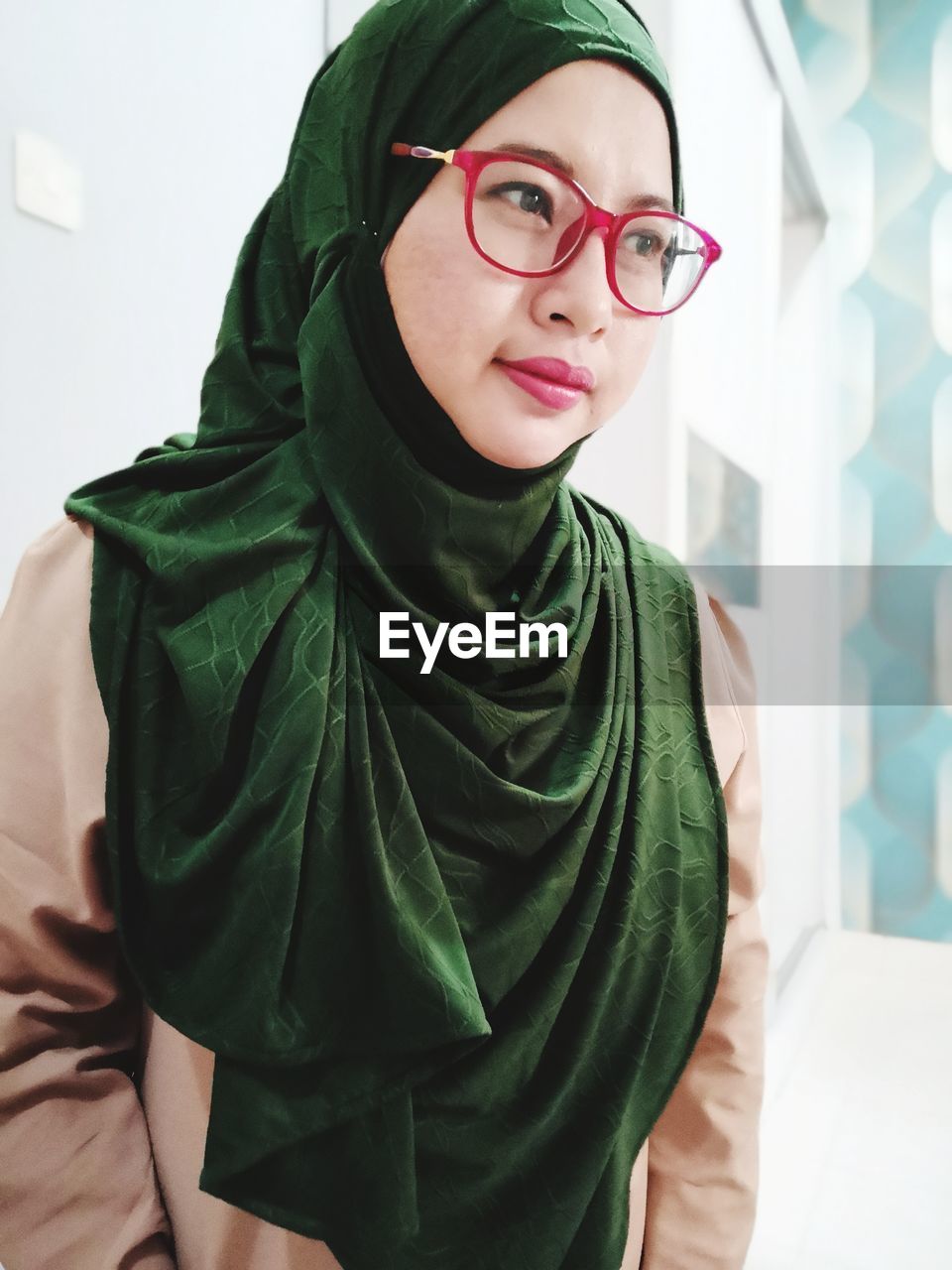 Woman wearing hijab and eyeglasses looking away in city