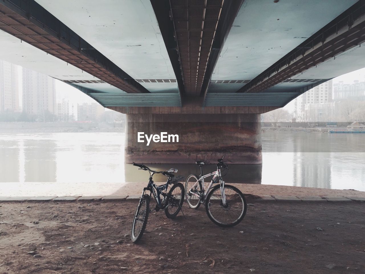 Bicycles under bridge over river