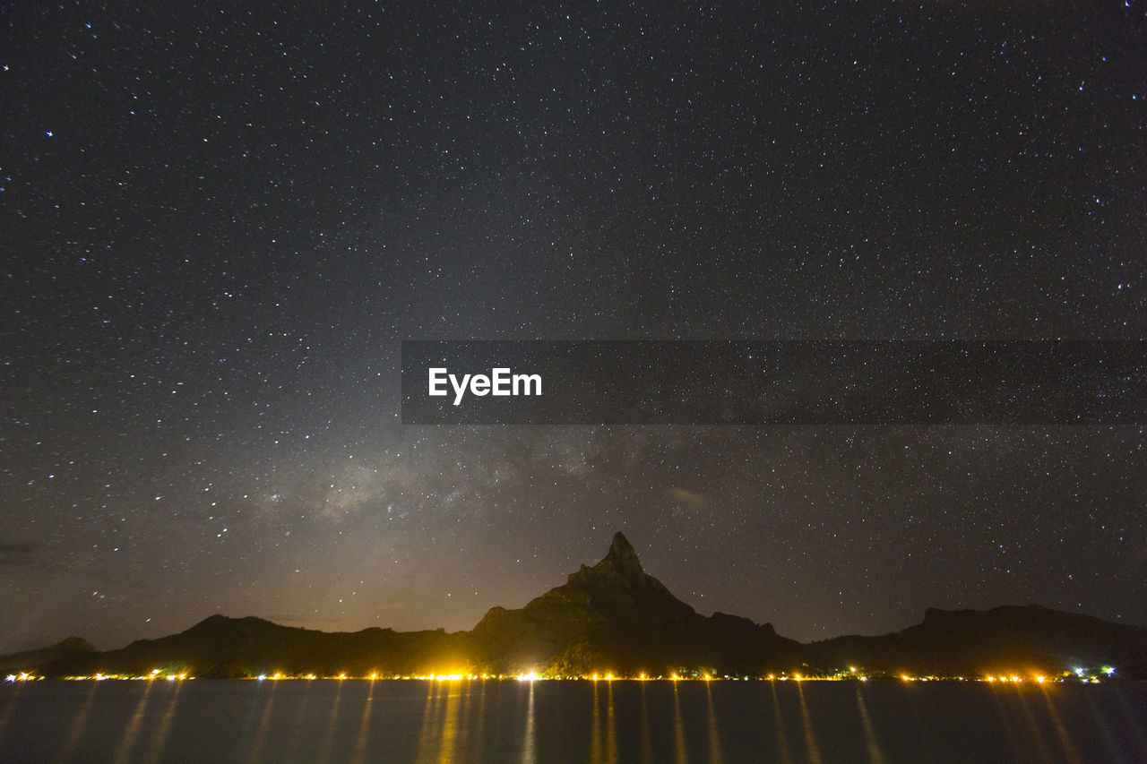 SCENIC VIEW OF MOUNTAINS AGAINST STAR FIELD AT NIGHT