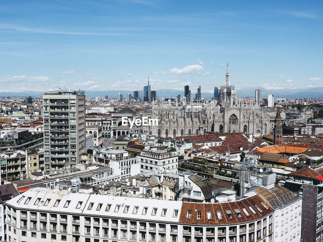 Aerial view of cityscape against sky during sunny day