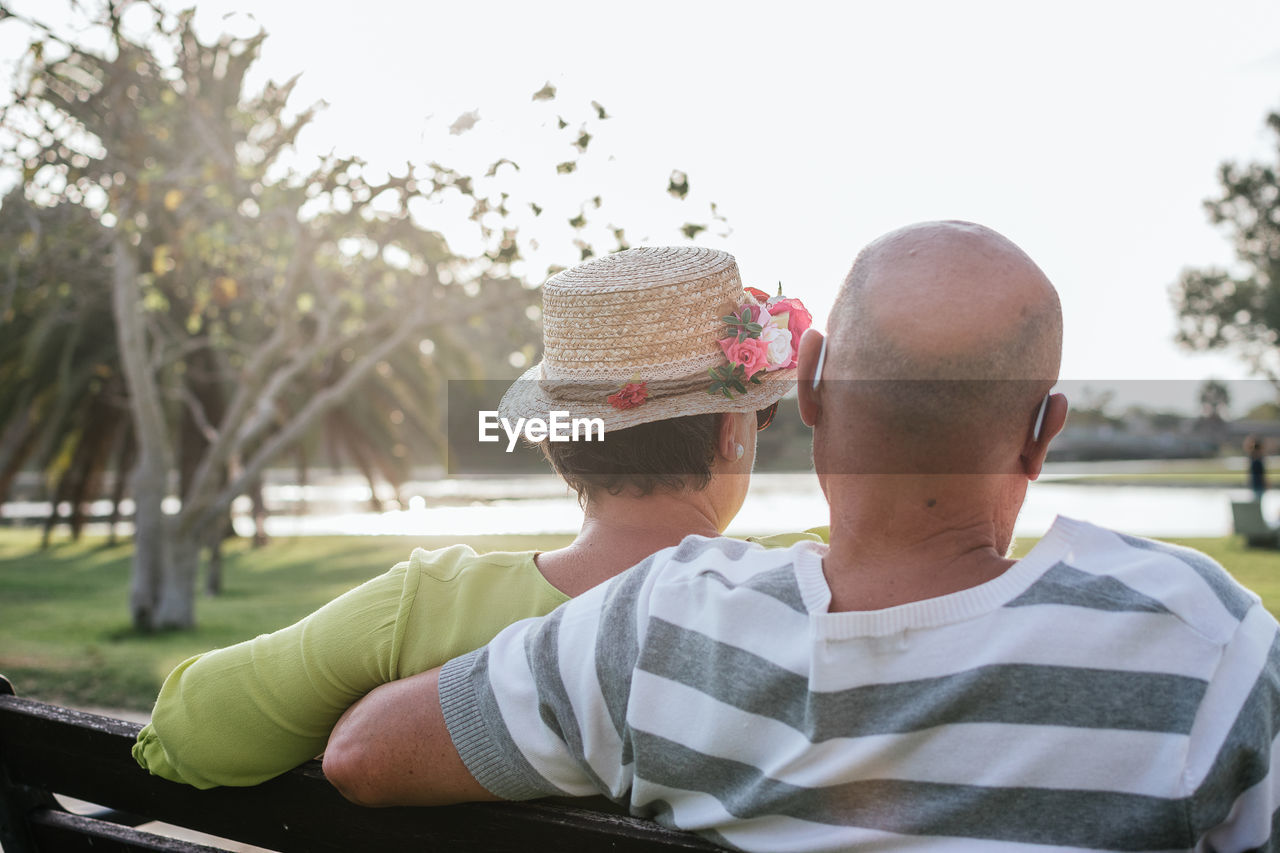 Couple of pensioners seen from behind sitting