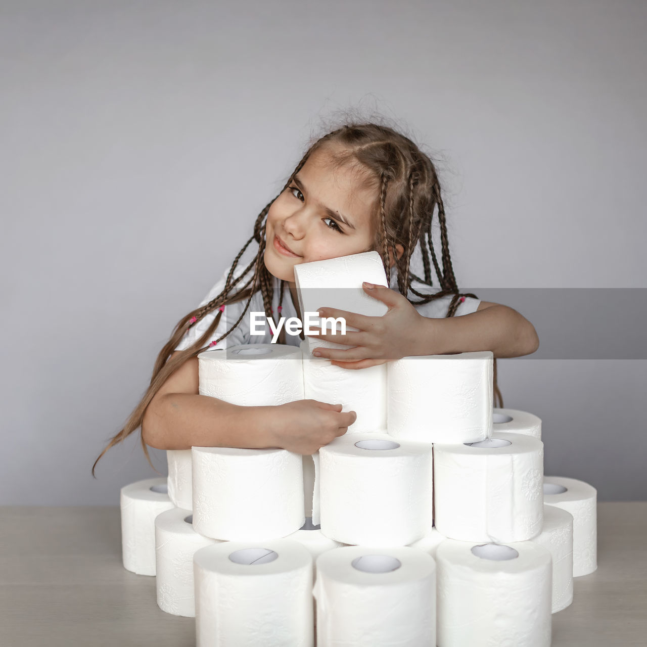 Close-up of smiling girl with toilet paper on table