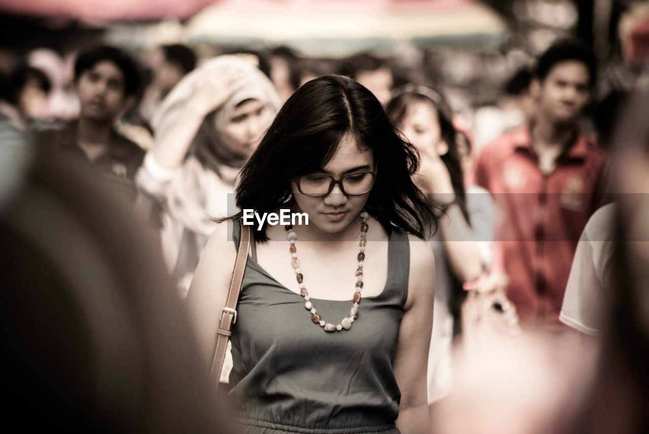 Young woman walking on busy street