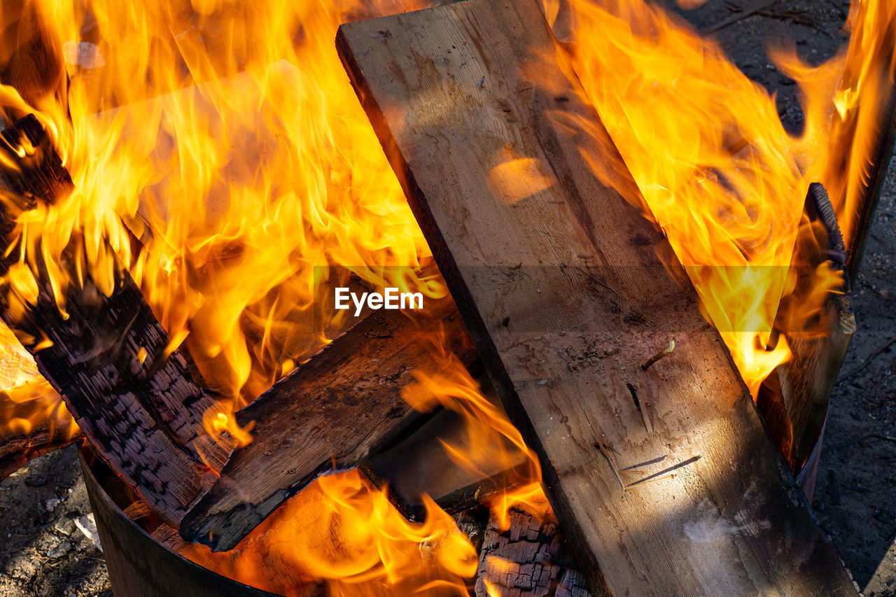 HIGH ANGLE VIEW OF FIRE BURNING IN WOOD