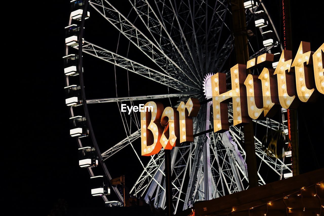 LOW ANGLE VIEW OF FERRIS WHEEL AT NIGHT