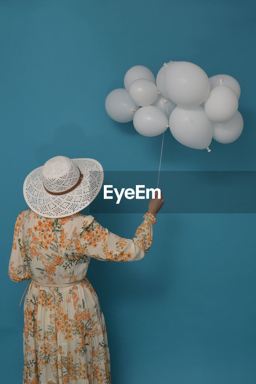 Cloudy day. concept with woman and white baloons against blue sky