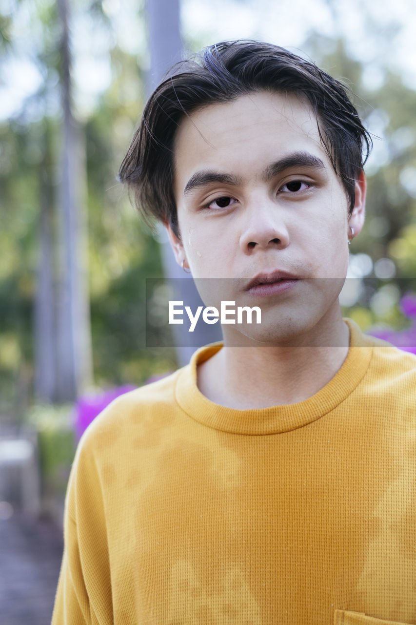 Portrait of young man standing at park