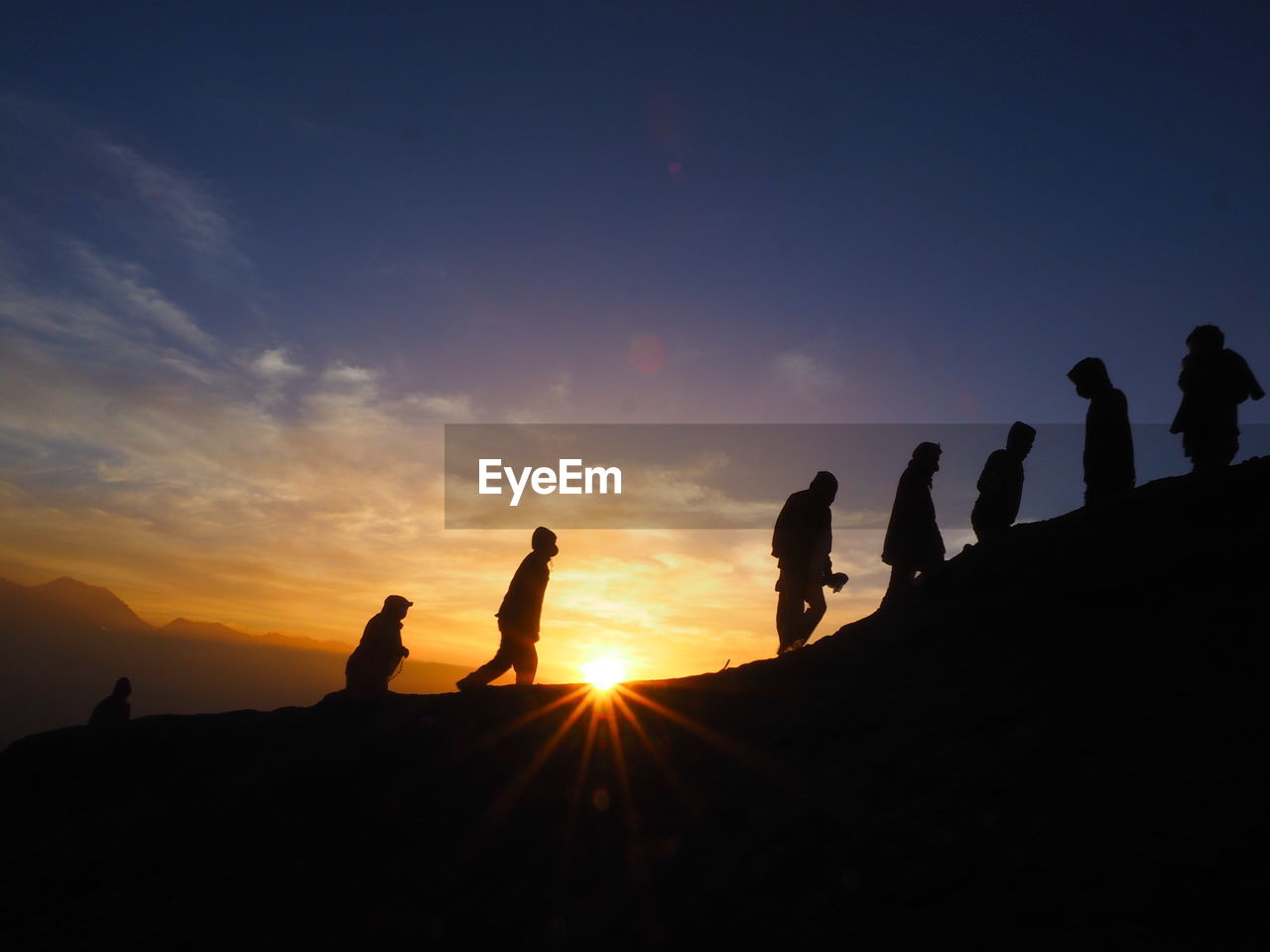 Silhouette people against sky during sunrise