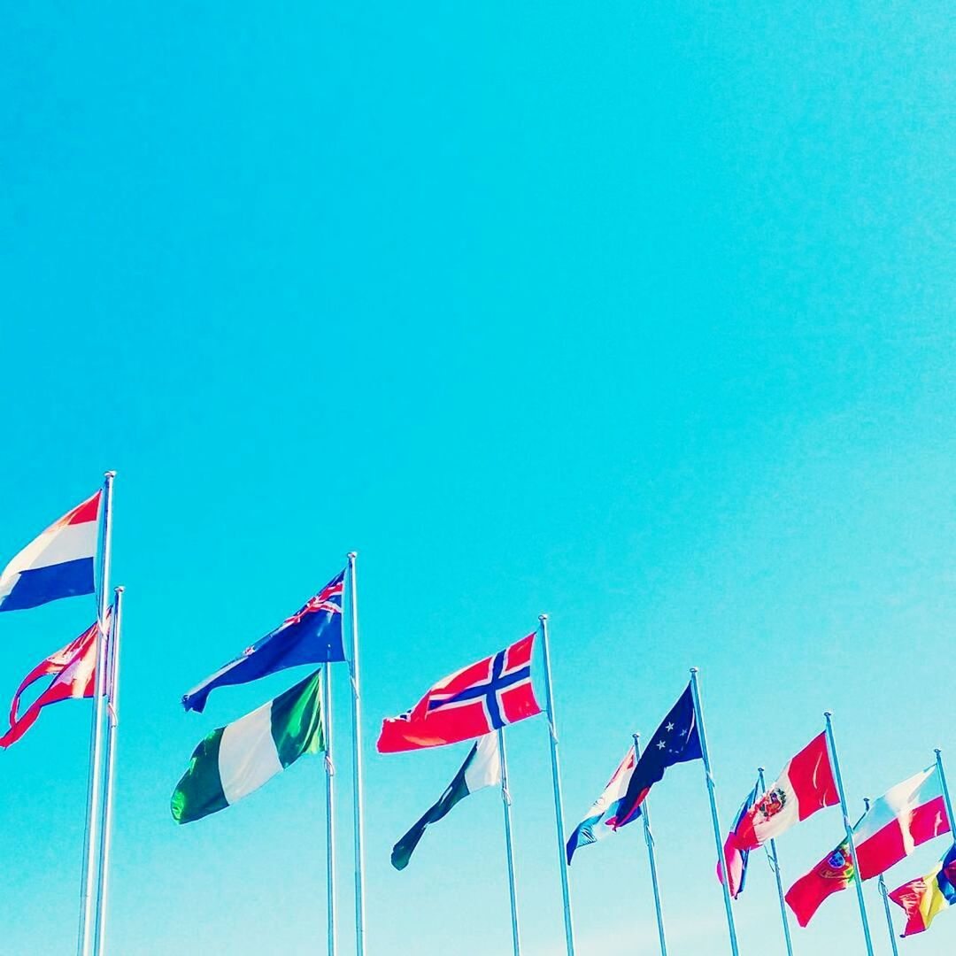 LOW ANGLE VIEW OF FLAGS FLAG AGAINST BLUE SKY