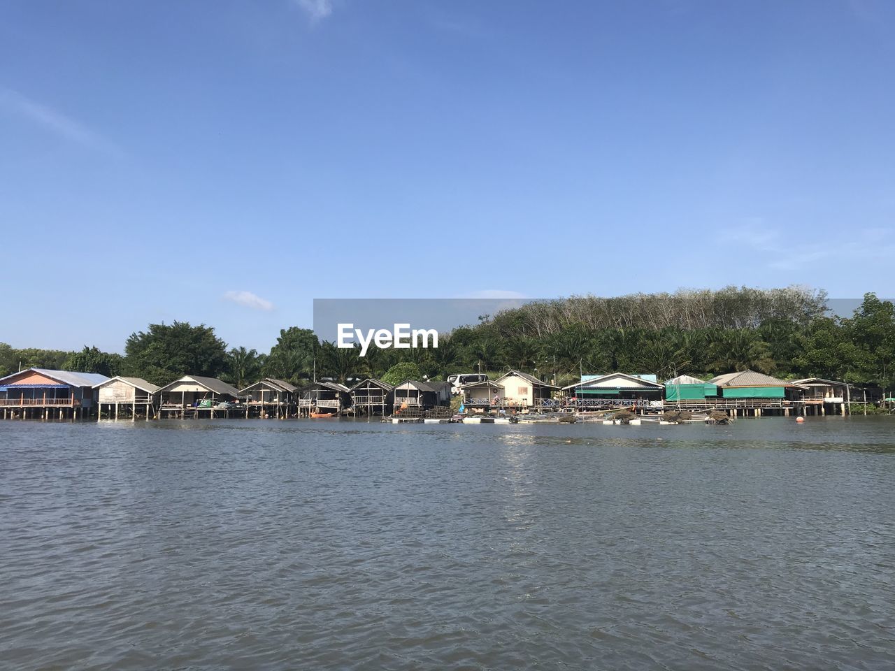 HOUSES BY LAKE AND BUILDINGS AGAINST SKY