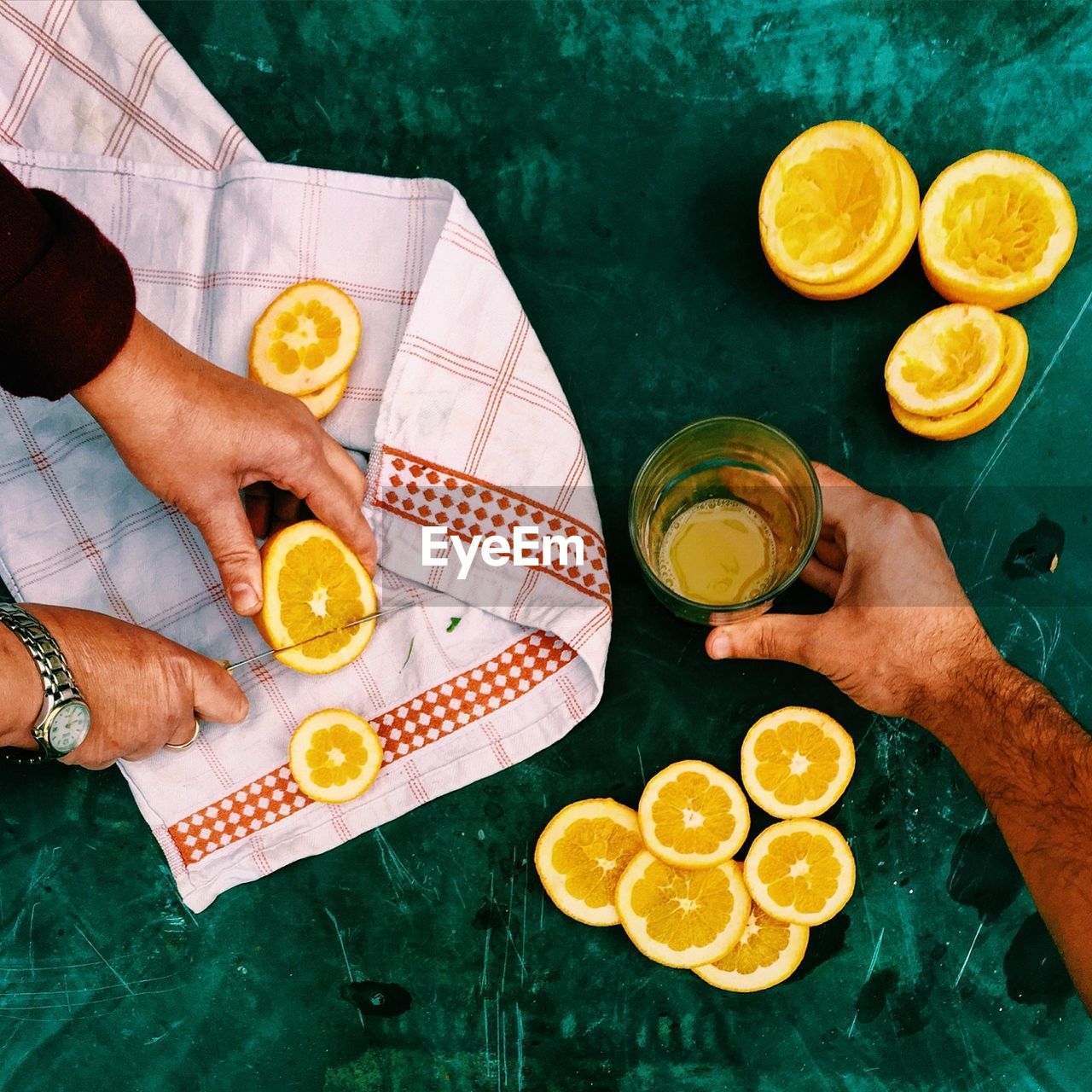 Cropped image of hands preparing orange juice