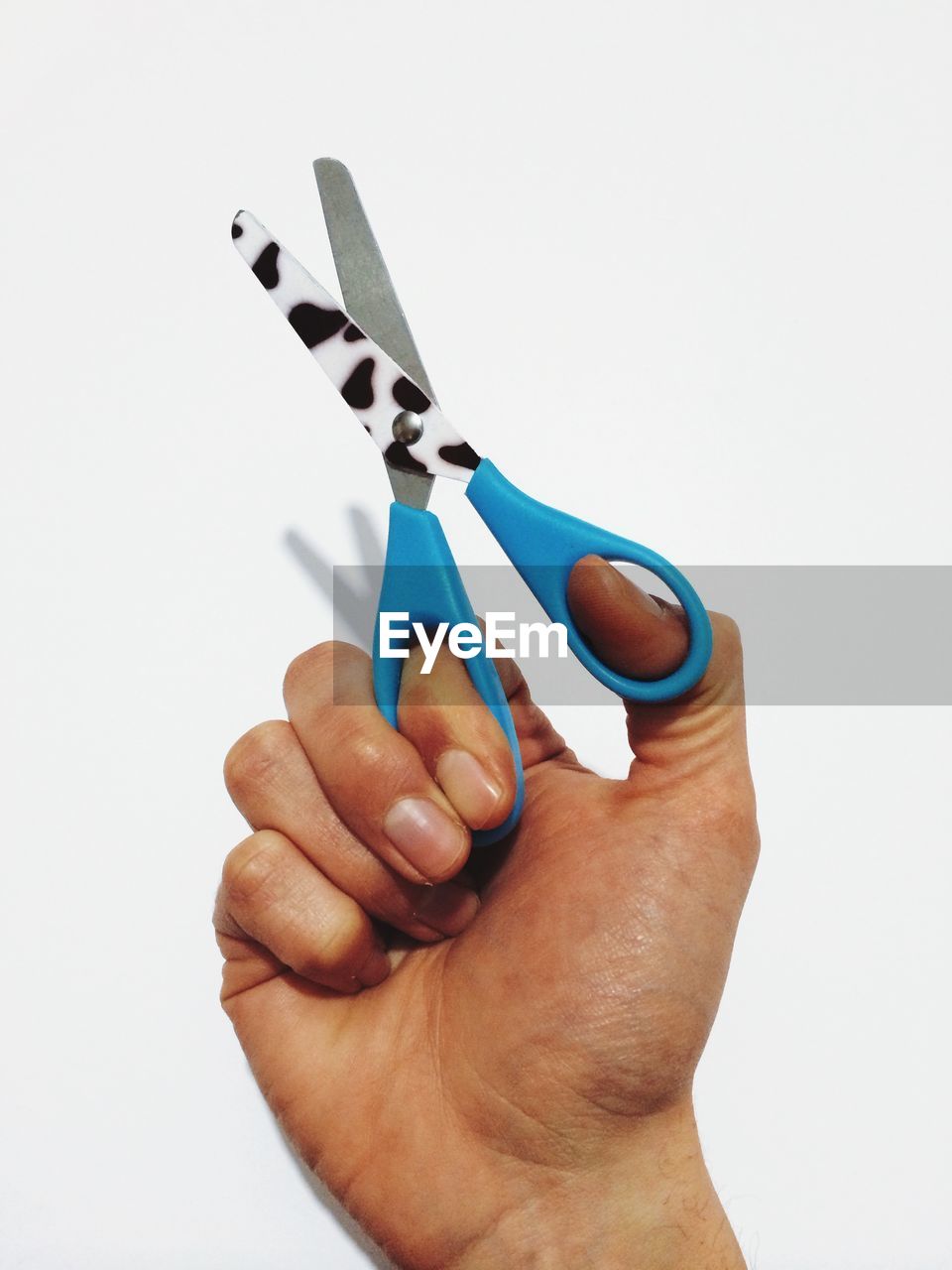 Cropped image of man holding scissors over white background