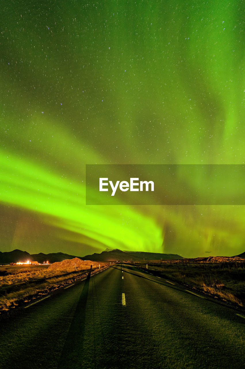 Scenic view of landscape against aurora filled sky at night