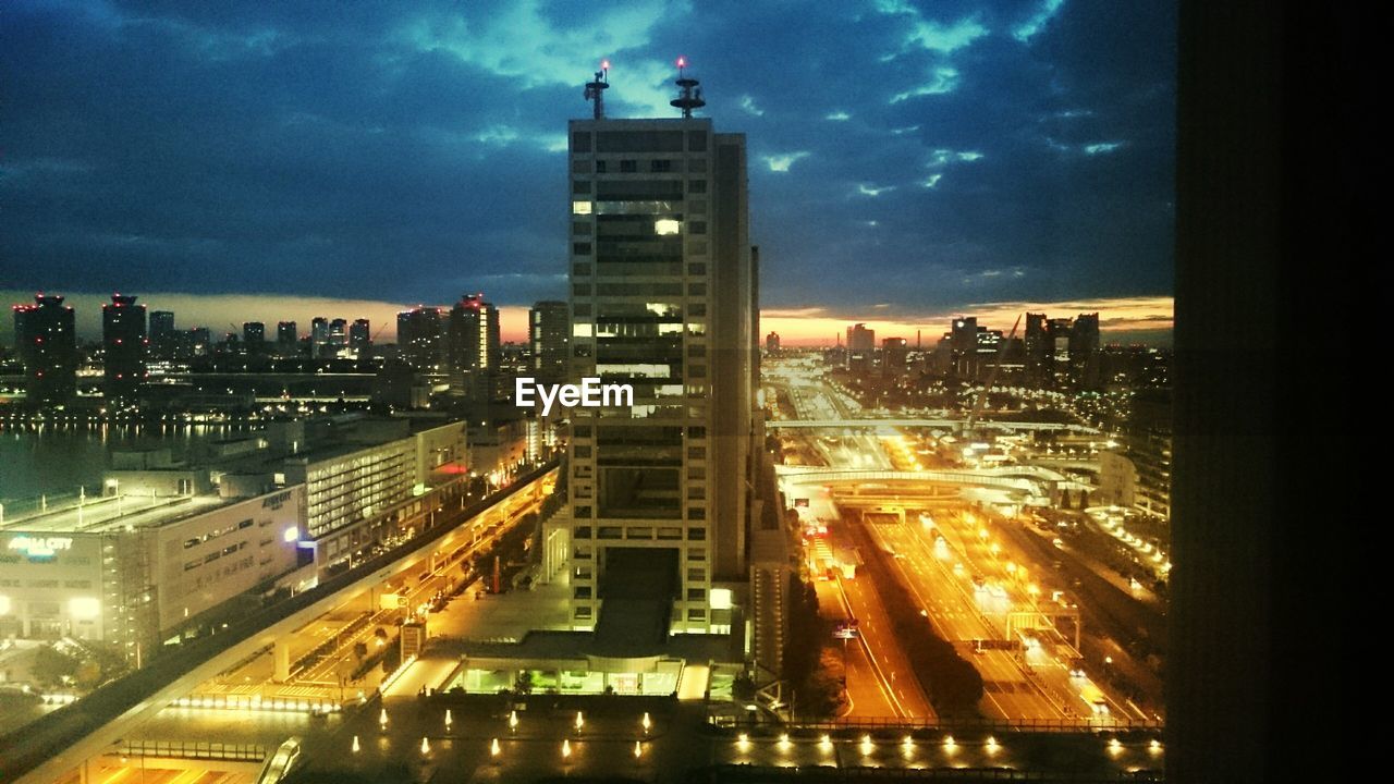 ILLUMINATED CITYSCAPE AGAINST SKY AT NIGHT