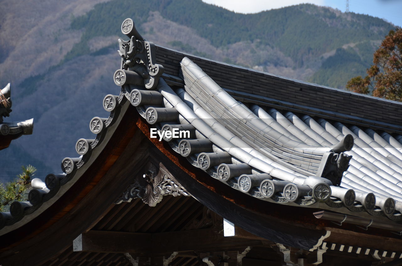 Low angle view of traditional house against cloudy sky