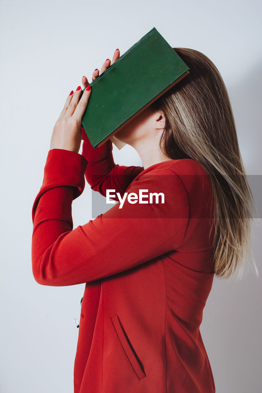 MIDSECTION OF WOMAN HOLDING RED UMBRELLA