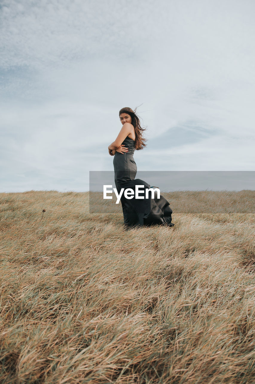 Woman standing on field against sky