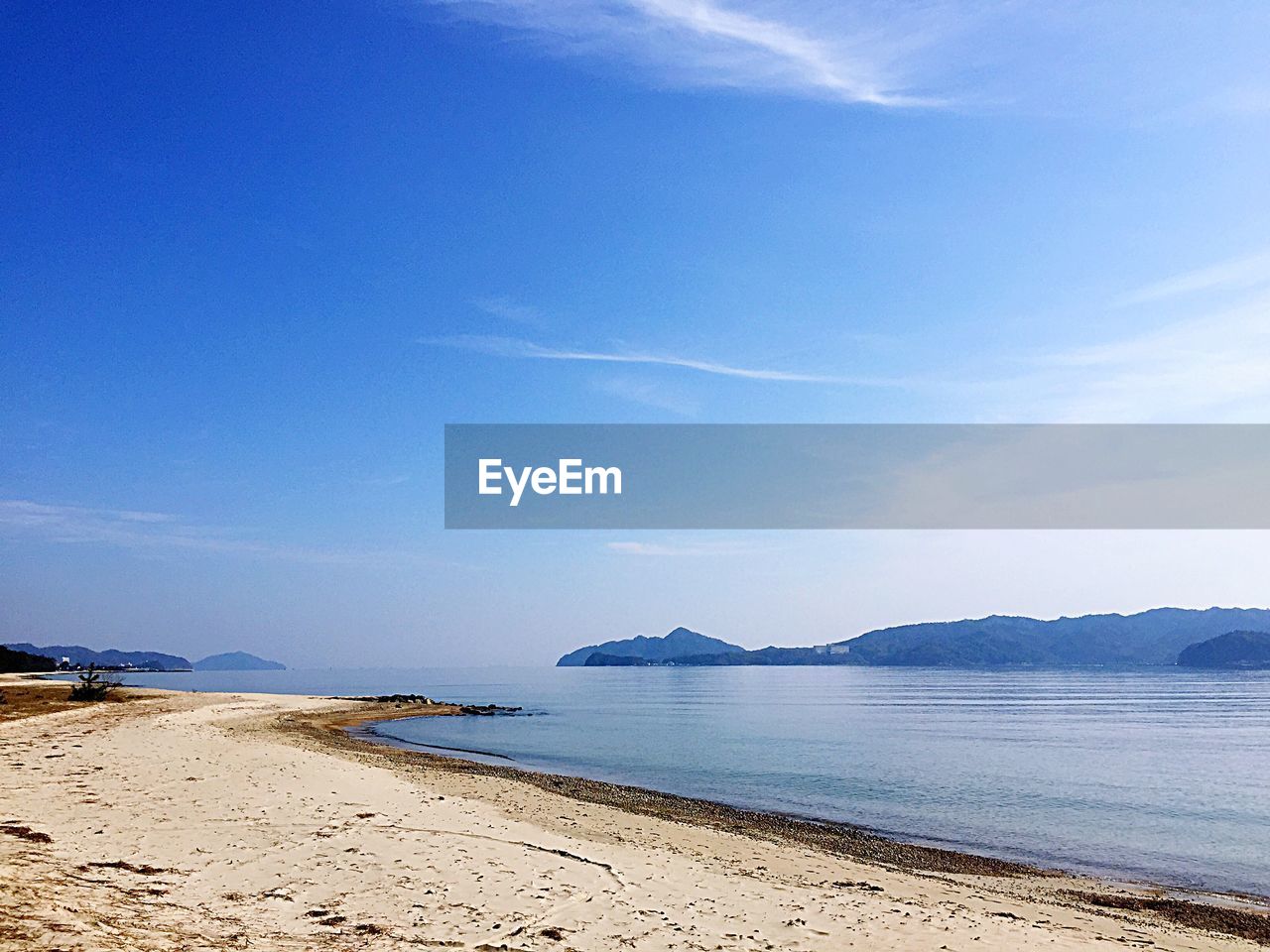 Scenic view of beach against blue sky