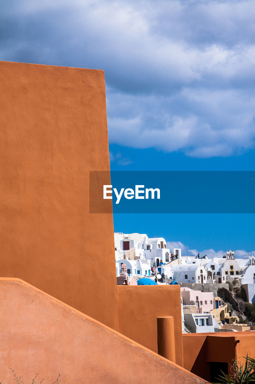 Buildings against cloudy blue sky at oia