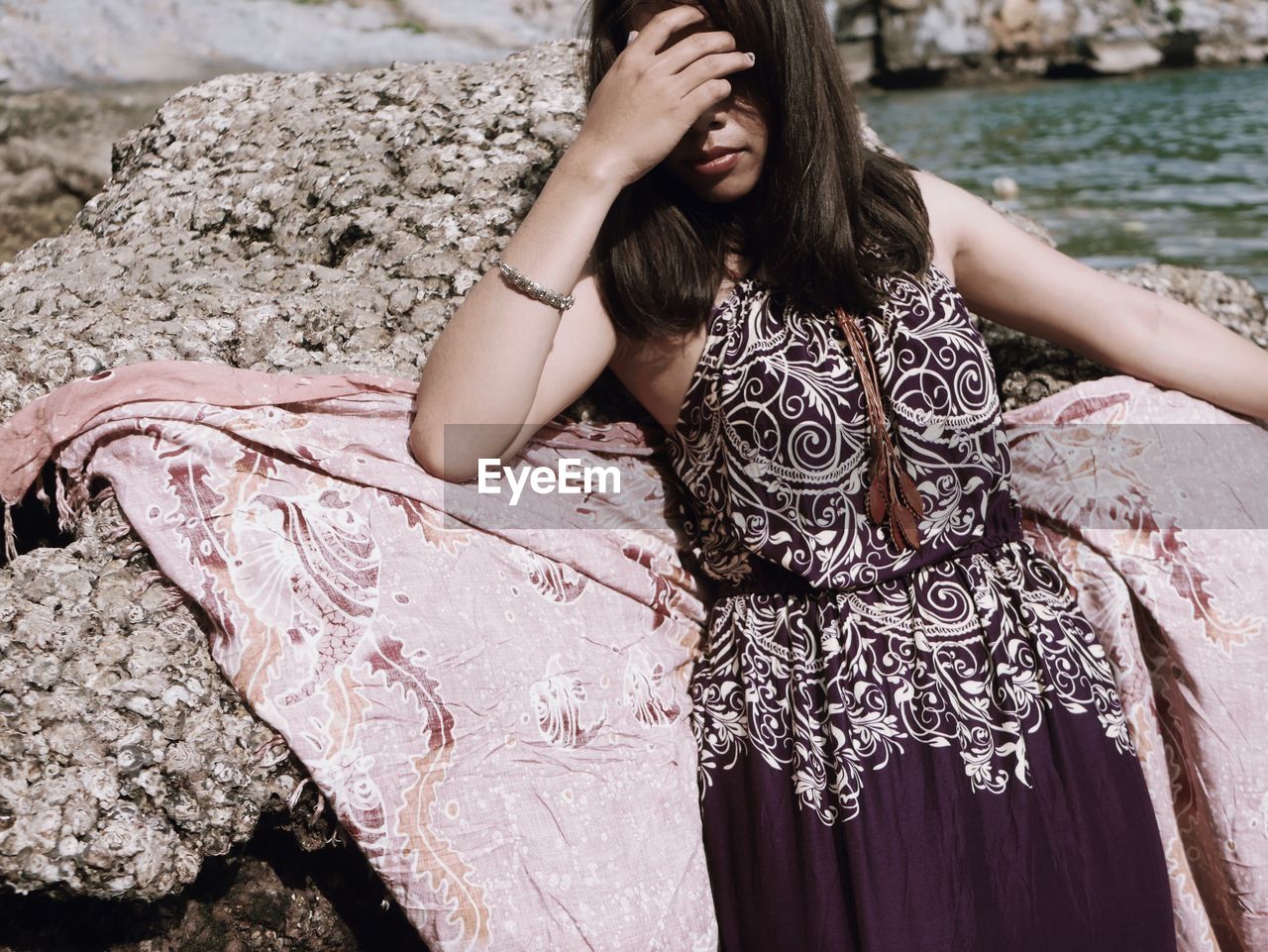 Young woman by rock at beach