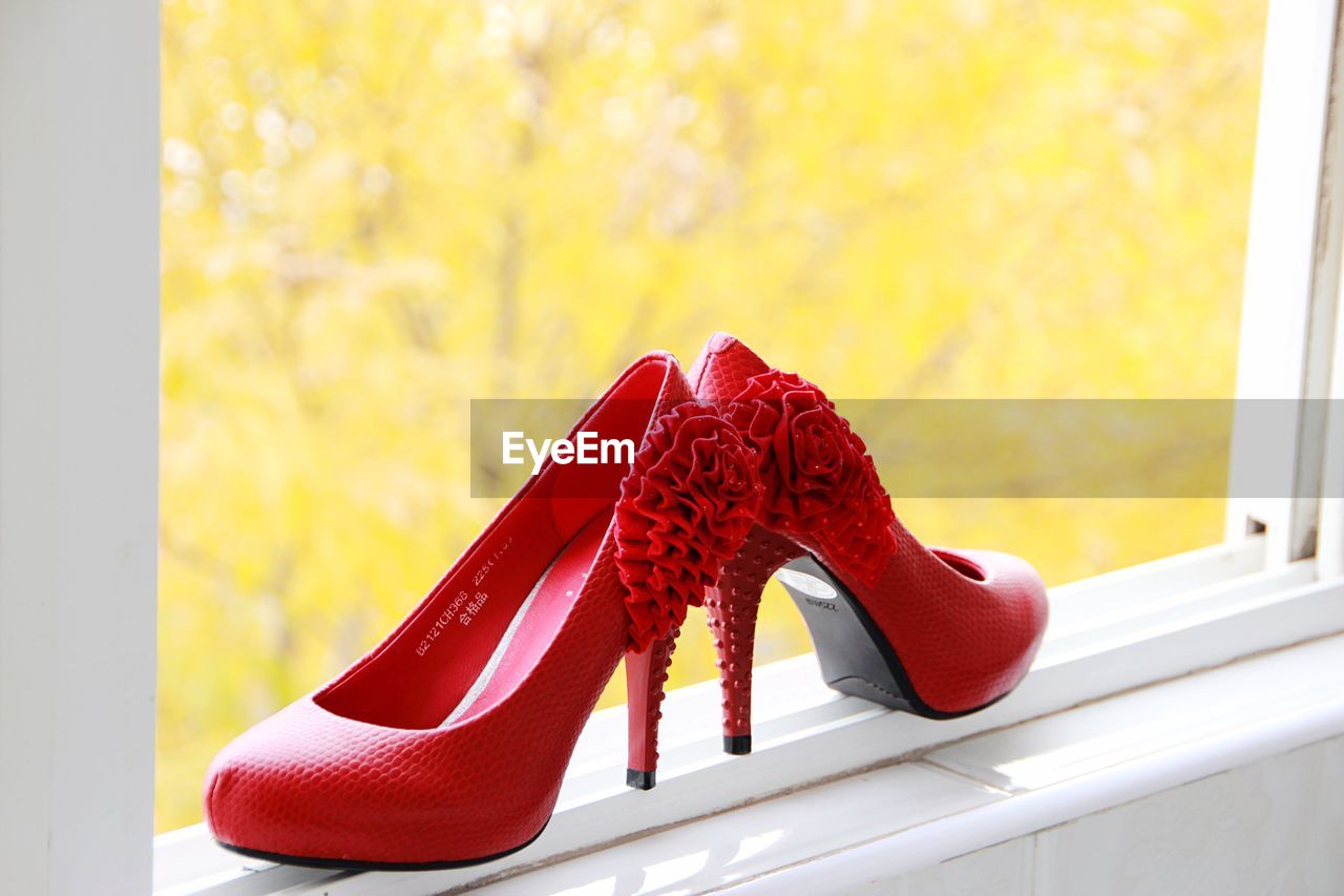 Red high heels on window sill